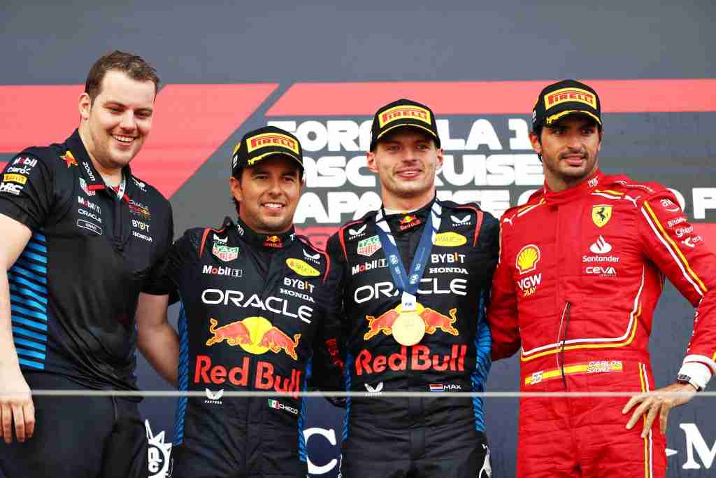 O vencedor da corrida Max Verstappen, o segundo colocado Sergio Perez e o terceiro colocado Carlos Sainz da Ferrari comemoram com Craig Dear, principal aerodinamicista da Red Bull Racing no pódio no Grande Prêmio do Japão de 2024 |  Conjunto de conteúdo Getty Images / Red Bull